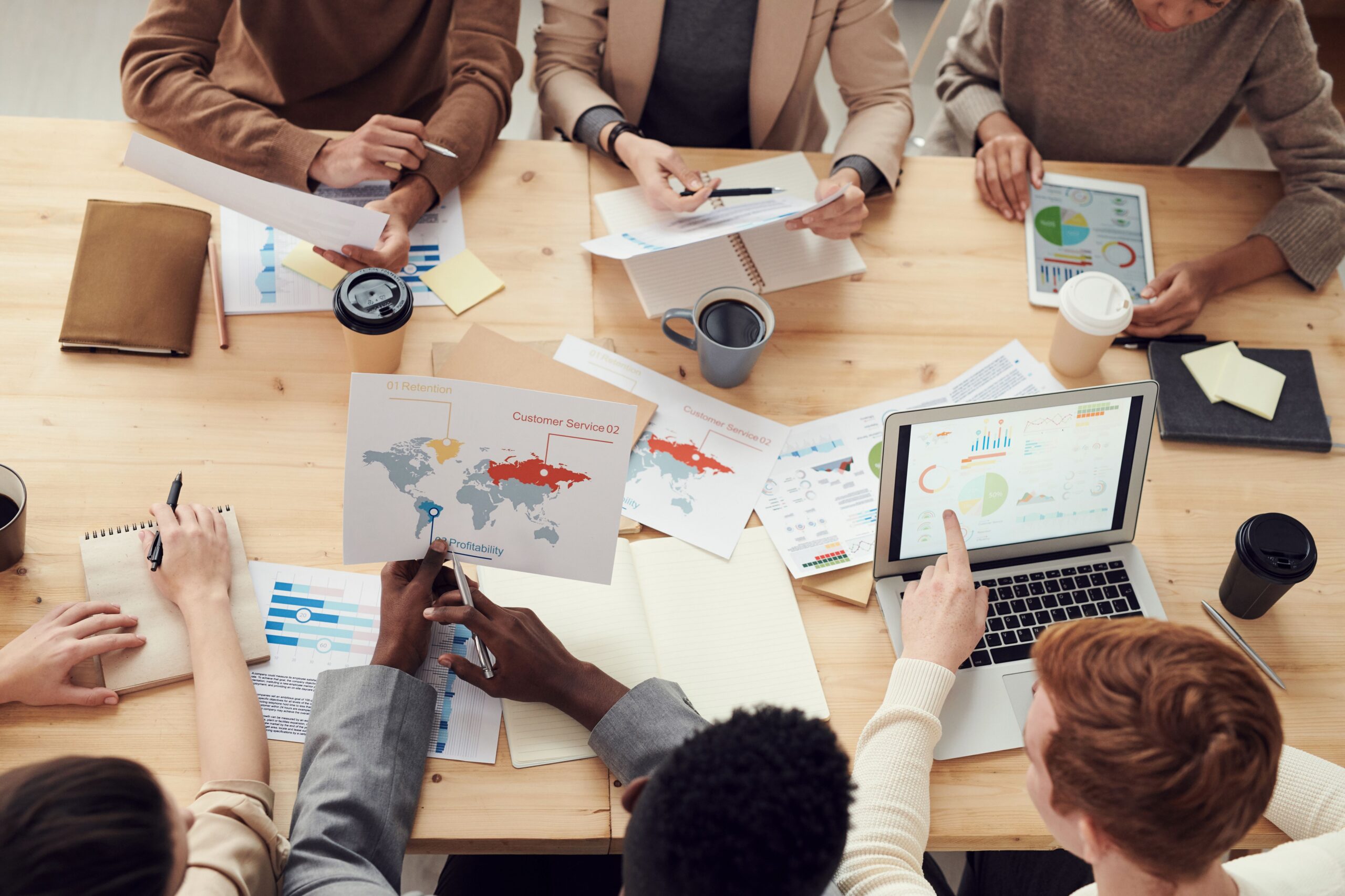 AI Advertising: 7 Powerful Updates Marketers Can Use Now 3 Marketing team mapping out a 30-day AI advertising test plan around a meeting table