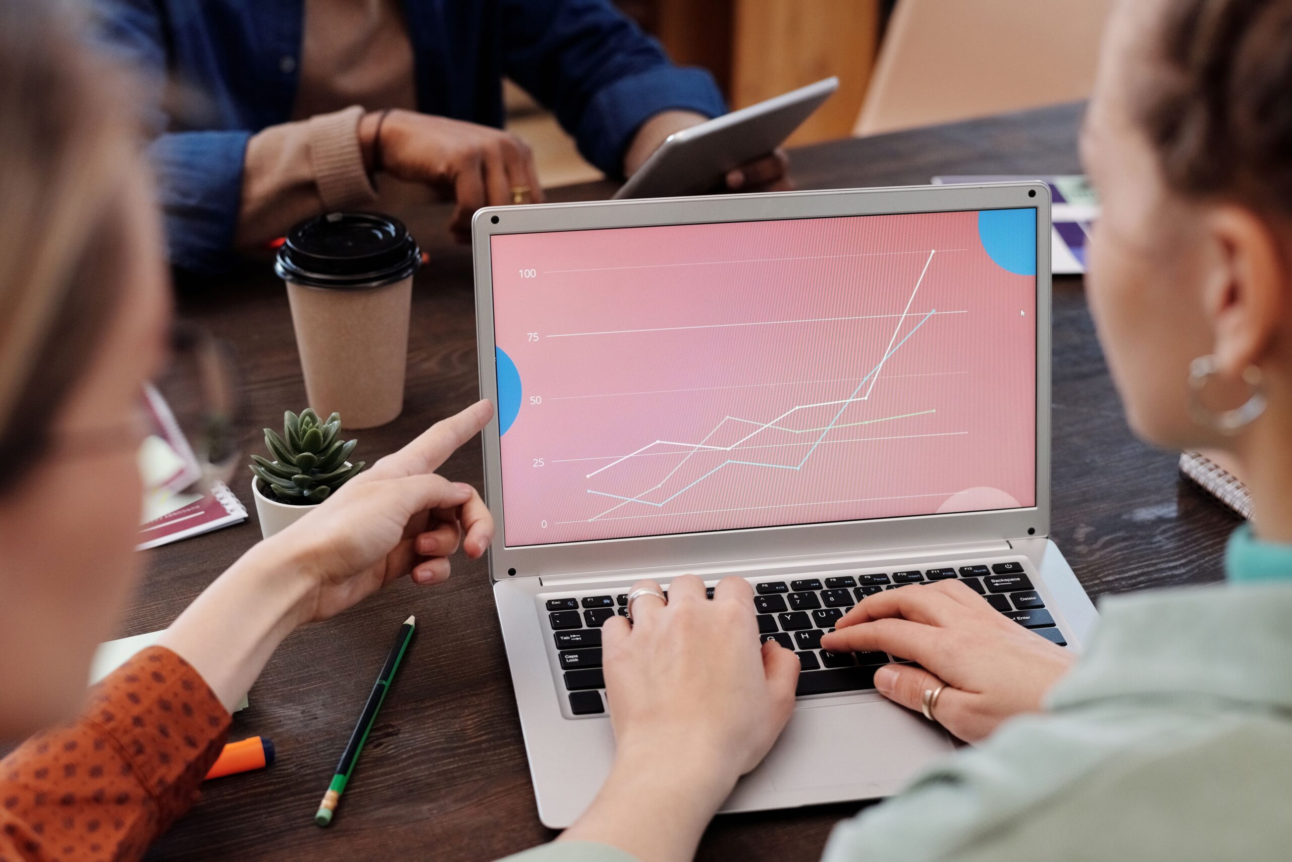 AI Advertising: 7 Powerful Updates Marketers Can Use Now 4 Strategist and colleague reviewing ad performance trends on a laptop before scaling budget